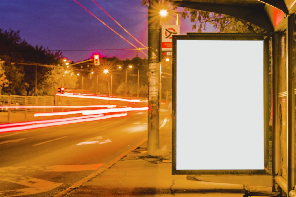 Baner reklamowy zawieszony na przystanku przy ruchliwej drodze