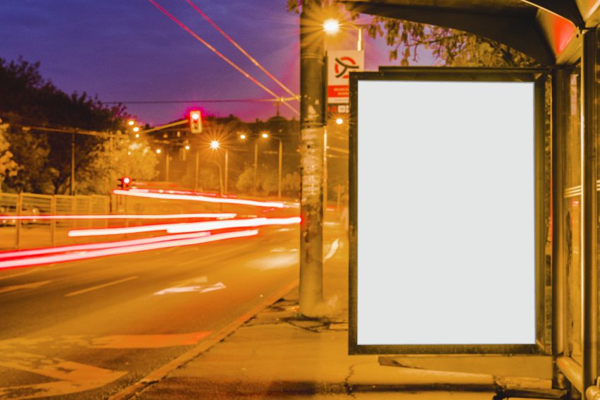 Baner reklamowy zawieszony na przystanku przy ruchliwej drodze