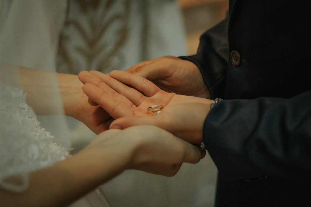zdjęcie rąk pary młodej i pierścionków