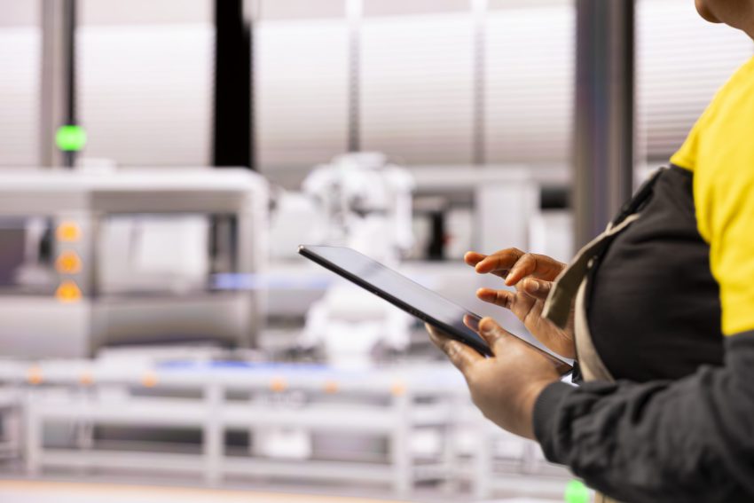 Pracownik hali produkcyjnej korzystający z tabletu do zarządzania automatyzacją poprzez mobilny system kontroli produkcji kraków.