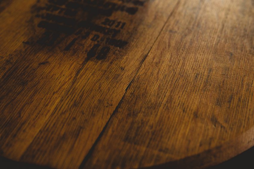 zdjęcie przedstawia zbliżenie na ciemniejszą, drewnianą powierzchnię – prawdopodobnie blat stołu